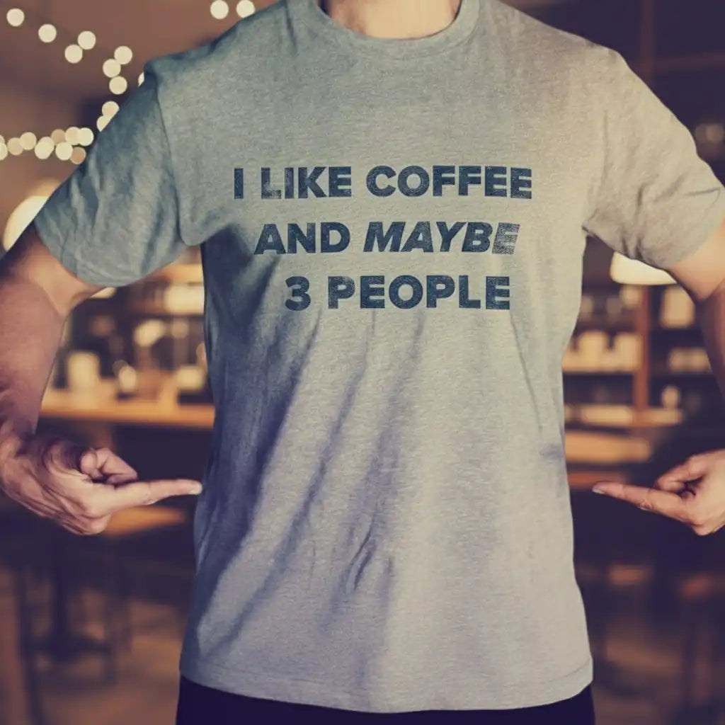 Man wearing a funny coffee t-shirt that says “I Like Coffee and Maybe 3 People,” printed in the USA by Sip & Shirt.