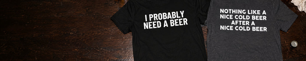 I Probably Need A Beer and Nothing Like a Nice Cold Beer t-shirts laid on a bar top next to two pints of beer